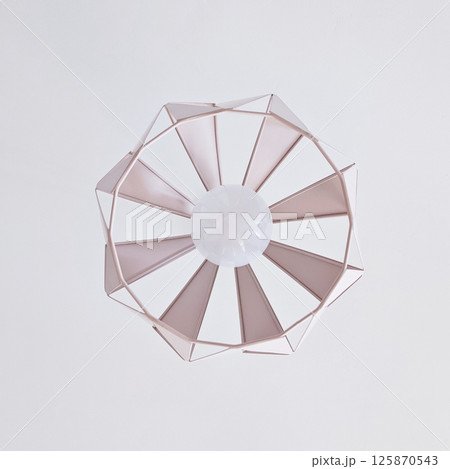 A stylish ceiling lamp illuminates a contemporary room design 125870543