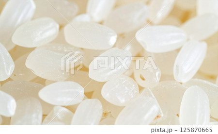 Japanese rice grains with a white and slightly translucent texture. Ideal for concepts related to healthy food, Asian cuisine, cooking ingredients, and traditional nutrition 125870665