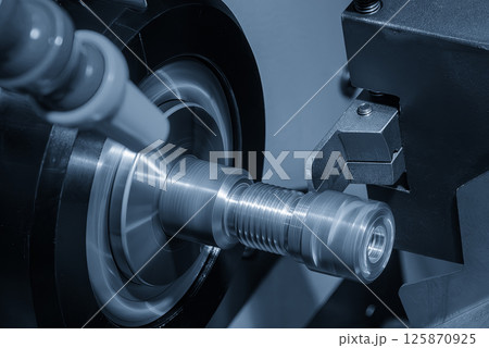 Close up scene the CNC lathe machine slot cutting at the end of brass pipe coupling parts in the light blue scene. 125870925