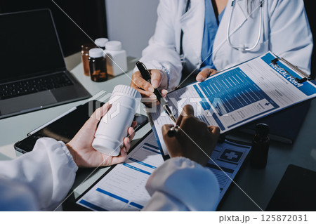 Male and female doctors are having a meeting in a hospital room. Male and female doctors are having a meeting in a hospital room. 125872031