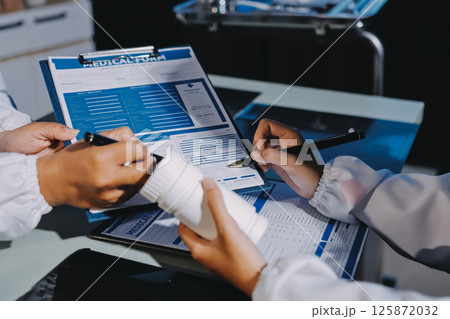 Male and female doctors are having a meeting in a hospital room. Male and female doctors are having a meeting in a hospital room. 125872032