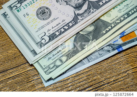 Dollars on a wooden table. Money on table. American dollars. Dollars on a wooden table. Money on table. American dollars. 125872664