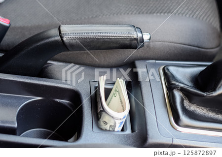 wad of dollars inside the car. wad of dollars inside the car. 125872897