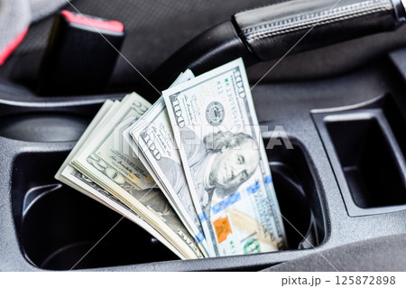 wad of dollars inside the car. wad of dollars inside the car. 125872898