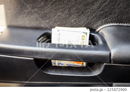 wad of dollars inside the car. wad of dollars inside the car. 125872900