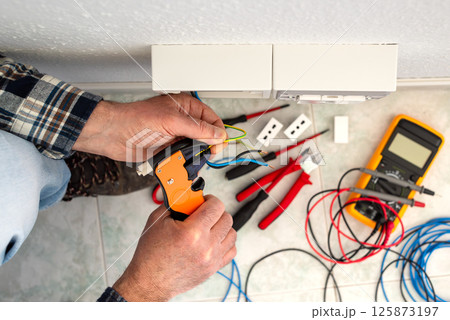 Electrician at work on a residential electrical system. Electricity. Electrician at work on a residential electrical system. Electricity. 125873197