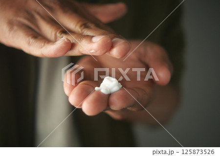 Applying moisturizer to hands during daily skincare routine 125873526