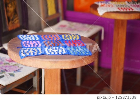 Colorful woven textile displayed on wooden table in craft market 125873539