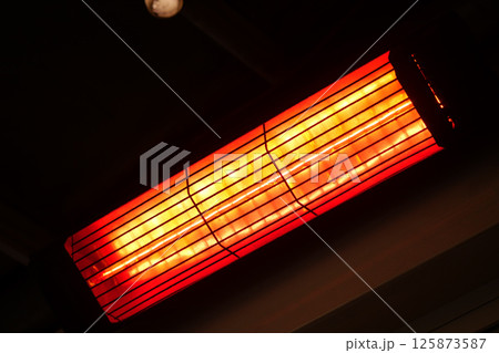 Bright heater radiating warmth in a cozy indoor space 125873587