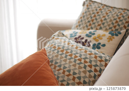 Decorative pillows arranged on a cozy couch in a bright room Decorative pillows arranged on a cozy couch in a bright room 125873870