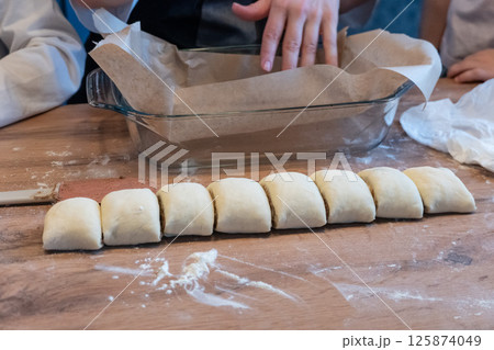 Woman preparing traditional cinnamon rolls in kitchen Woman preparing traditional cinnamon rolls in kitchen 125874049