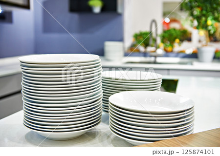 Stacks of plates on kitchen table Stacks of plates on kitchen table 125874101