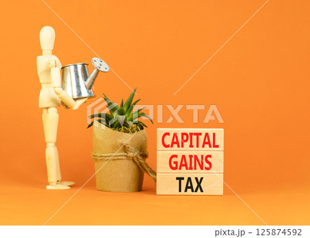 Capital gains tax symbol. Concept words Capital gains tax on beautiful wooden block. Businessman model. Beautiful orange background. Business and capital gains tax concept. Copy space. Capital gains tax symbol. Concept words Capital gains tax on beautiful wooden block. Businessman model. Beautiful orange background. Business and capital gains tax concept. Copy space. 125874592