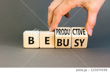 Be productive not busy symbol. Concept words Be productive Be busy on wooden block. Beautiful grey table grey background. Businessman hand. Business be productive not busy concept. Copy space. 125874599