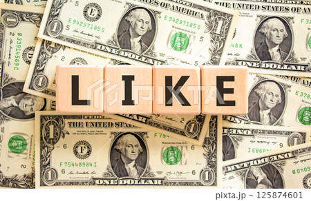 Like symbol. Concept word Like on beautiful wooden blocks. Dollar bills. Beautiful background from dollar bills. Business, lifestyle, support and like concept. Copy space. 125874601