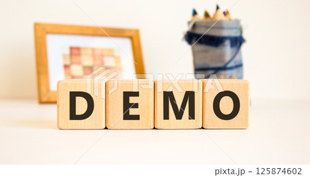 Demo symbol. Concept word Demo on beautiful wooden blocks. Beautiful picture frame and colored pencils. Beautiful white table white background. Business and demo concept. Copy space. Demo symbol. Concept word Demo on beautiful wooden blocks. Beautiful picture frame and colored pencils. Beautiful white table white background. Business and demo concept. Copy space. 125874602