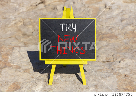 Try new things symbol. Concept words Try new things on beautiful blackboard. Beautiful brown stone beach background. Business motivational lifestyle try new things concept. Copy space. Try new things symbol. Concept words Try new things on beautiful blackboard. Beautiful brown stone beach background. Business motivational lifestyle try new things concept. Copy space. 125874750
