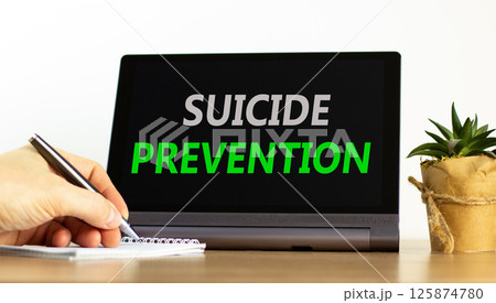 Suicide prevention symbol. Concept words Suicide prevention on beautiful tablet. Psychologist hand. Beautiful wooden table white background. Psychological suicide prevention concept. Copy space. 125874780