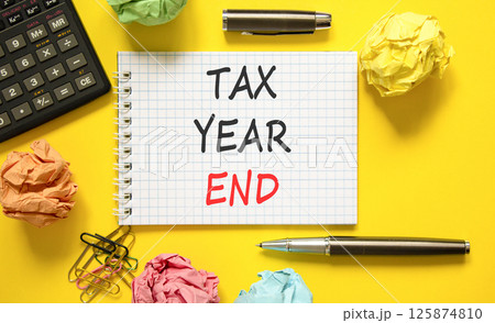 Tax year end symbol. Concept words Tax year end on beautiful white note. Beautiful yellow background. Black pen. Black calculator. Business tax year end concept. Copy space. Tax year end symbol. Concept words Tax year end on beautiful white note. Beautiful yellow background. Black pen. Black calculator. Business tax year end concept. Copy space. 125874810