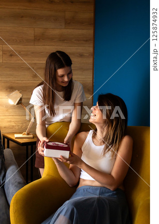 Loving family celebrating mother's day, 8 march, mom birthday. Smiling young woman receiving present from preteen daughter. Loving family celebrating mother's day, 8 march, mom birthday. Smiling young woman receiving present from preteen daughter. 125874932