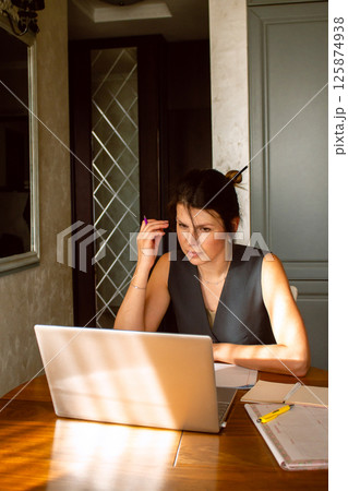 Concentrated business woman working in home office. Calculating incomes and expanses. Counting budget. Remote work. Concentrated business woman working in home office. Calculating incomes and expanses. Counting budget. Remote work. 125874938