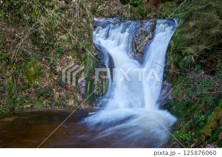 Majestic Allerheiligen Waterfalls: Serene Long Exposure Cascade in Black Forest National Park Germany. Scenic Forest Stream Flows Through Lush Greenery and Moss Covered Rocks Creating Ethereal Majestic Allerheiligen Waterfalls: Serene Long Exposure Cascade in Black Forest National Park Germany. Scenic Forest Stream Flows Through Lush Greenery and Moss Covered Rocks Creating Ethereal 125876060