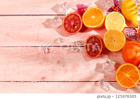 Modern still life with exotic citrus fruits on sunny table with shadows from palm tree,summer holiday concept.Summer banner with tropical fruits,healthy vegan food for weight loss 125876305