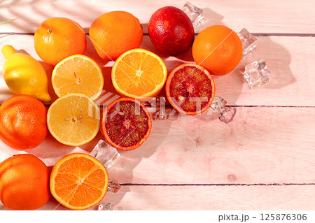 Modern still life with exotic citrus fruits on sunny table with shadows from palm tree,summer holiday concept.Summer banner with tropical fruits,healthy vegan food for weight loss 125876306