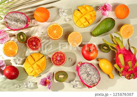 Summer exotic tropical fruits, fruit background. Dragon fruit, pitahaya, mango, blood orange, lemons, kiwi, oranges and fresh juices, banner for cafe or shop, postcard for advertising Asian market 125876307