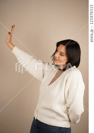 A universal expression of halting action or setting boundaries. A single hand raised with an open palm delivers a clear "stop" signal. The firm gesture conveys authority and the need to pause. 125876315