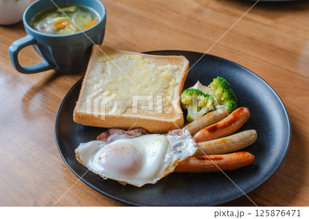 チーズトーストと目玉焼きの洋朝食プレート 125876471