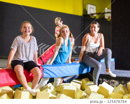 Group of excited active kids having fun while spending their weekend at indoor playground trampoline center 125876784