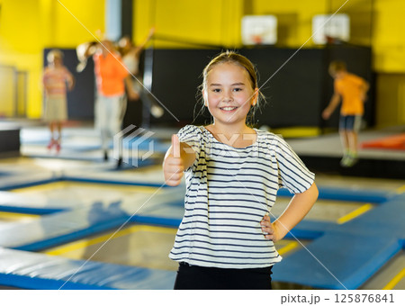Girl against the background of children playing in an amusement park 125876841