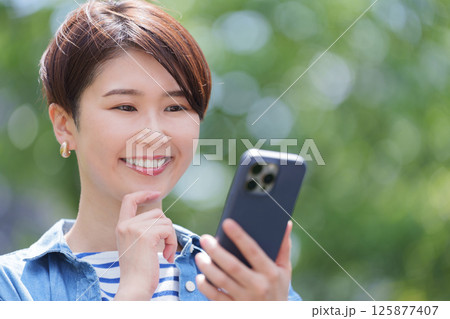 スマホを見て考える女性 スマホを見て考える女性 125877407