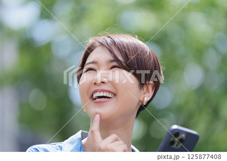 スマホを見て考える女性 125877408