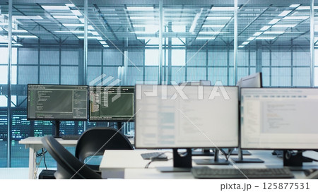 Code running on computer screens in empty data center workspace, used for troubleshooting rackmounts. Close up of script working on desktop PC monitors upgrading mainframes systems in server room Code running on computer screens in empty data center workspace, used for troubleshooting rackmounts. Close up of script working on desktop PC monitors upgrading mainframes systems in server room 125877531