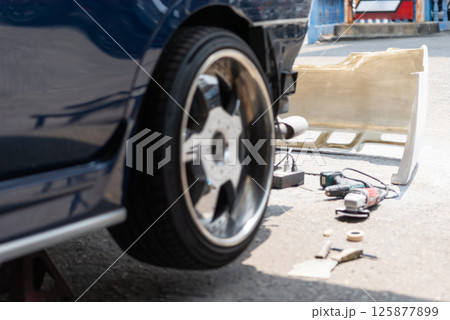 Checking car body work fiber bumper at car garage 125877899