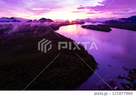 Aerial view landscape mountains colorful purple sky over sea Aerial view landscape mountains colorful purple sky over sea 125877960
