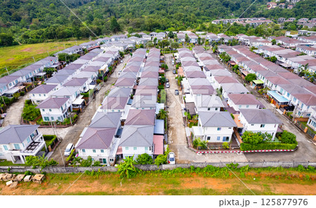 New development real estate. Aerial view of residential houses and driveways neighborhood during a fall sunset or sunrise time. Tightly packed homes. Top view over private houses in phuket thailand New development real estate. Aerial view of residential houses and driveways neighborhood during a fall sunset or sunrise time. Tightly packed homes. Top view over private houses in phuket thailand 125877976