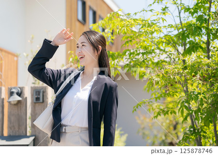 玄関を出るスーツ姿の女性 125878746