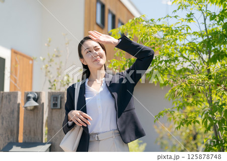 玄関を出るスーツ姿の女性 125878748