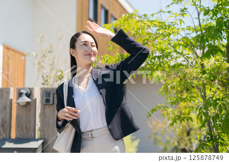 玄関を出るスーツ姿の女性 125878749