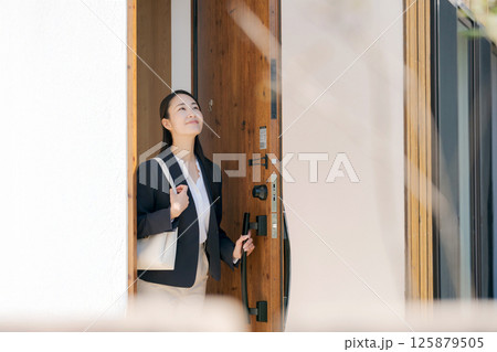 玄関を出るスーツ姿の女性 玄関を出るスーツ姿の女性 125879505