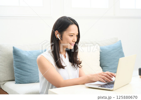 パソコン画面を真剣に見る女性 リビング ワンルーム パソコン画面を真剣に見る女性 リビング ワンルーム 125880670