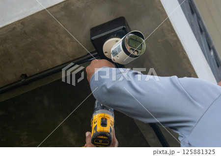 Technician installing CCTV camera system for security area Technician installing CCTV camera system for security area 125881325