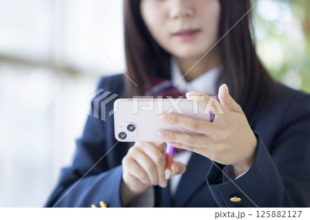 スマホを使って勉強する女子高校生の手元 スマホを使って勉強する女子高校生の手元 125882127