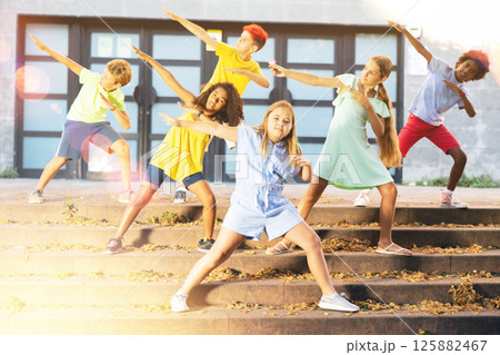 Group of kids performing street dance outdoors Group of kids performing street dance outdoors 125882467