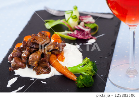Grilled chicken hearts with sauce and vegetables 125882500