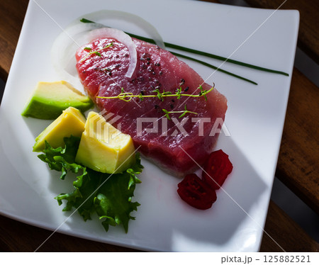 Seared tuna steaks with avocado, greens 125882521