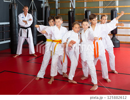 Schoolchilds practicing new technique in karate class 125882612